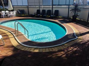 a large swimming pool with stairs in a building at Main Street Motel in Hervey Bay