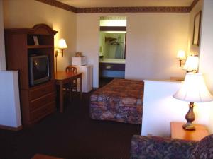 a hotel room with two beds and a television at Countryside Suites Omaha in Chalco