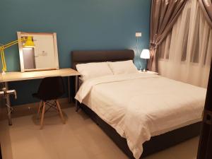 a bedroom with a bed and a desk with a mirror at Mike's Place @ The Majestic Ipoh in Ipoh