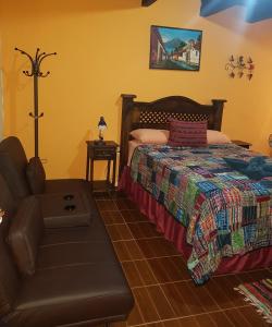 1 dormitorio con 1 cama y 1 silla en Hotel Casa del Cerro, en Antigua Guatemala