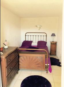 a bedroom with a bed and a wooden dresser at Bas De Maison in Olivese