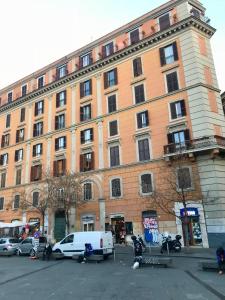 un grand bâtiment avec des voitures garées devant dans l'établissement san cosimato suite, à Rome