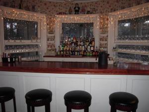 een bar met krukken voor een bar met alcohol bij Brookview Manor Inn in Canadensis
