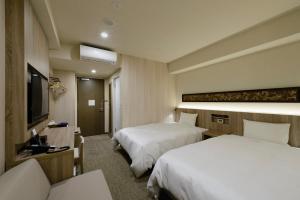 a hotel room with two beds and a television at Hotel Il Fiore Kasai in Tokyo