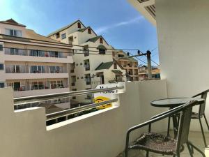 un balcón con mesa y sillas y un edificio en Malee House and Restaurant en Pattaya Central