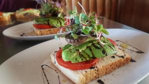 un plato blanco con un sándwich con una ensalada. en Greenfire Drakensberg Lodge en Bonjaneni