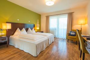 Pokój hotelowy z dużym łóżkiem i biurkiem w obiekcie Gesundheitszentrum Bärenhof w mieście Bad Gastein +37 zdjęć