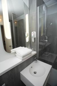 a bathroom with a sink and a shower and a mirror at ibis Lyon Gerland Merieux in Lyon