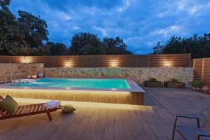 a swimming pool in a backyard at night at All Seasons Villas in Gállos