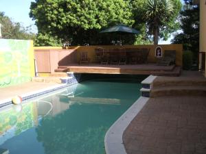 uma piscina com uma mesa e um guarda-sol em 50 on Theal em Parow