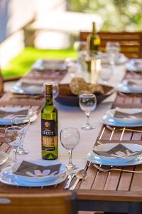 uma mesa de madeira com uma garrafa de vinho e copos em Villa Lovran, heated pool and Spa em Lovran