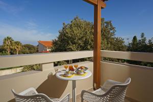 a table on a balcony with glasses of wine at All Seasons Villas in Gállos