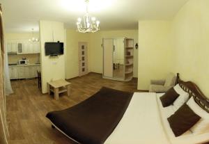 a bedroom with a large bed and a living room at Studio on Sobornaya in Mykolaiv