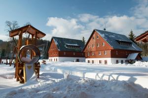 eine Person, die im Schnee vor einer Scheune läuft in der Unterkunft Rodinný penzion Skiland in Ostružná