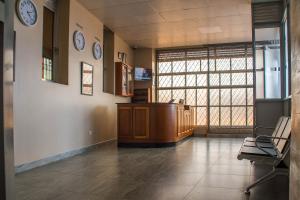 a waiting room with a desk and clocks on the wall at Kenendia Hotel in Kampala