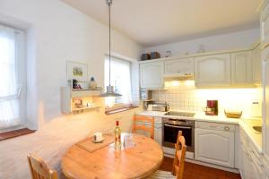 a kitchen with a wooden table with a bottle of wine at Wohnung-Wattseite in Munkmarsch