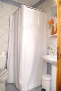 a bathroom with a white shower curtain and a sink at Xenonas Chrisso in Delfoi