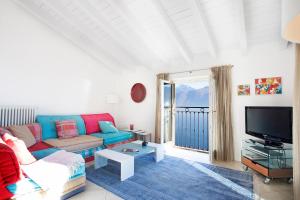 メナッジョにあるBelvedere Menaggio-4 Luxury homes-by Italian Apartments Casa Paradiso, Apartmento Belvedere, Woon Belvedere Apartment Penthouse, VH apartment Bella Vistaのソファとテレビのあるリビングルーム