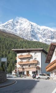 een gebouw met een met sneeuw bedekte berg op de achtergrond bij Alpin Garni die kleine Post in Solda