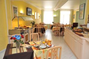 un restaurant avec une table et de la nourriture dans l'établissement Hotel Menton Riviera, à Menton