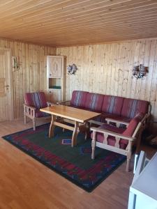 - un salon avec un canapé et une table en bois dans l'établissement Nybu Two-bedroom cottage, à Geilo