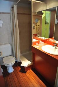 a bathroom with a toilet and a sink and a shower at Hotel Menton Riviera in Menton