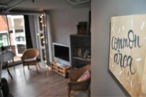 a living room with a tv and a living room with chairs at Quartier Bilbao Hostel Casco Viejo in Bilbao