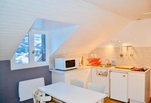 a kitchen with a table and a microwave at Location Le Queron in Guillestre