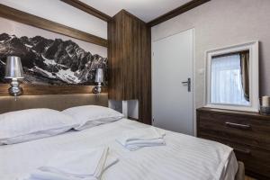 ザコパネにあるApartament Helena Odkryj Zakopaneのベッドルーム(大きな白いベッド1台、窓付)