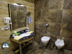 a bathroom with a sink and a toilet at Atlas City Center Hotel in Prilep +31 photos