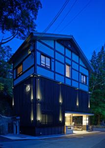 une maison noire éclairée la nuit dans l'établissement Mizuhasou, à Miyajima