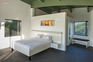 a white bedroom with a bed and two windows at Serene-estate Boutique Guesthouse in St Lucia