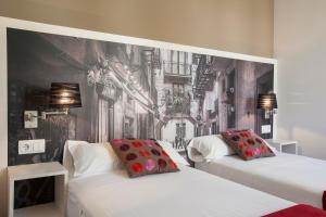バルセロナにあるBCNGOTIC 22のベッドルーム1室(ベッド2台付)が備わります。壁に壁画が飾られています。
