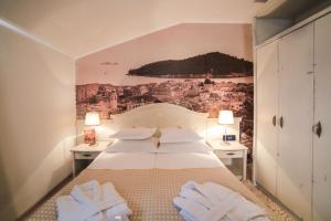 Schlafzimmer mit einem Bett mit Wandgemälde in der Unterkunft Boutique Hotel Marco Polo in Gradac