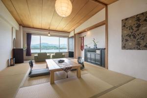 een woonkamer met een tafel en een open haard bij Hana Irodori no Yado Kayuu in Taiji