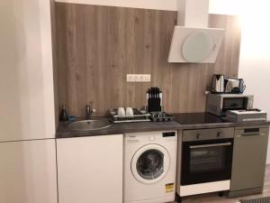 a kitchen with a washing machine and a sink at The Whistling Rabbi in Budapest