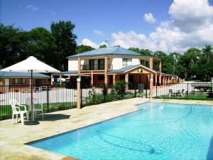 a house with a swimming pool in front of a house at Seminara Apartments Coochiemudlo Island in Coochiemudlo