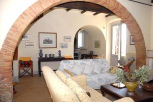 a living room with a white couch and an archway at Podere San Giovanni in Montoro