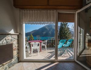 una porta di vetro che conduce a un patio con tavolo e sedie di Villa Bellavista a Ledro