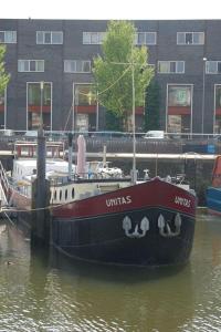 a boat is docked in the water next to a building at B&B Unitas in Rotterdam