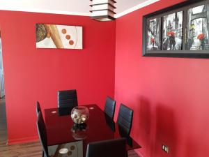 a dining room with red walls and a table and chairs at Home Apartments in Los Ángeles