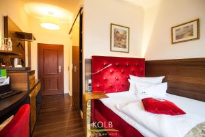 a hotel room with a bed with a red headboard at Hotel Kolb in Langeoog