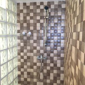 a shower in a bathroom with a tiled wall at Casa del Almezo in Almodóvar del Río +24 photos