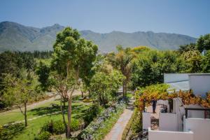 
a large garden area with trees and shrubbery at Aan de Oever Guesthouse in Swellendam
