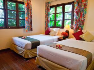2 Betten in einem Zimmer mit Fenstern in der Unterkunft Baan Klang Aow Beach Resort in Ban Krut