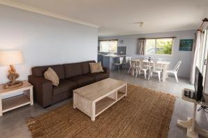 a living room with a couch and a table at Seascape Beach House in Minnie Water