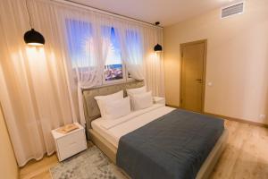 een slaapkamer met een groot bed en een raam bij Vorobyovy Gory Hotel in Kurgan