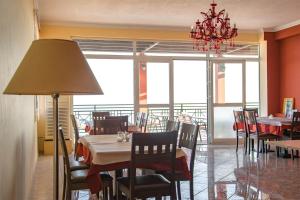 a dining room with tables and chairs and a chandelier at Saint Catherine Hotel in Pythagoreio
