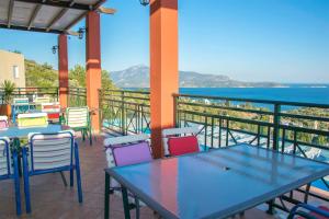 eine Terrasse mit Tischen und Stühlen und Meerblick in der Unterkunft Saint Catherine Hotel in Pythagoreio