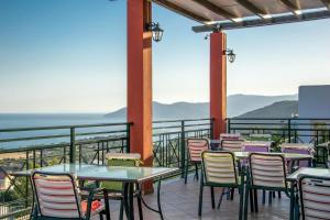a group of tables and chairs on a balcony at Saint Catherine Hotel in Pythagoreio
